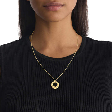Γυναικείο Κολιέ Calvin Klein 35000761 ατσάλινο χρυσό με στρογγυλό μενταγιόν, φορεμένο.